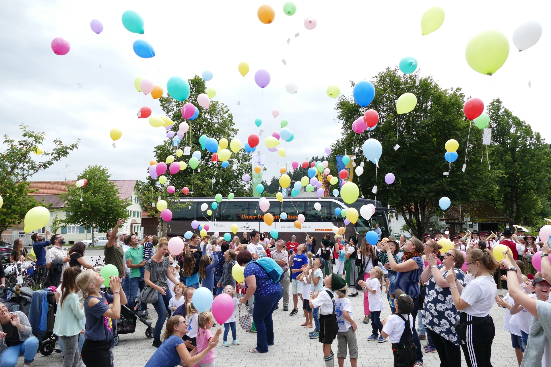 Im Dorf Gestratz lassen die Menschen Luftballons steigen.